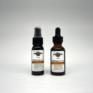 May include: Two glass bottles with brown labels. The bottles are labeled "Hungry Bear Farms" and contain Propolis Spray and Propolis Tincture. The bottles are 1 fluid ounce each.