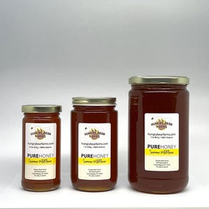 May include: Three glass jars of honey in different sizes. The jars are labeled "Hungry Bear Farms" and contain "Pure Honey Summer Wildflower".