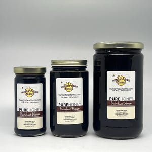May include: Three glass jars of honey in different sizes. The jars are labeled "Hungry Bear Farms" and "Pure Honey Buckwheat Blossom". The largest jar is 2 lbs, the middle jar is 1 lb, and the smallest jar is 1/2 lb.