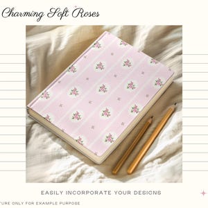 Puede incluir: Un cuaderno rosa con un dise&ntilde;o floral y el texto "Charming Soft Roses". Dos l&aacute;pices dorados descansan junto al cuaderno. La cubierta presenta un patr&oacute;n repetitivo de rayas rosas y medallones florales. Tambi&eacute;n se ve el texto "EASILY INCORPORATE YOUR DESIGNS".