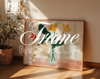 May include: A framed art print mockup featuring a floral watercolor painting with yellow and red flowers in a glass vase. The frame is light brown. The words "Frame Mockup" are in white script. A potted plant is in the corner.
