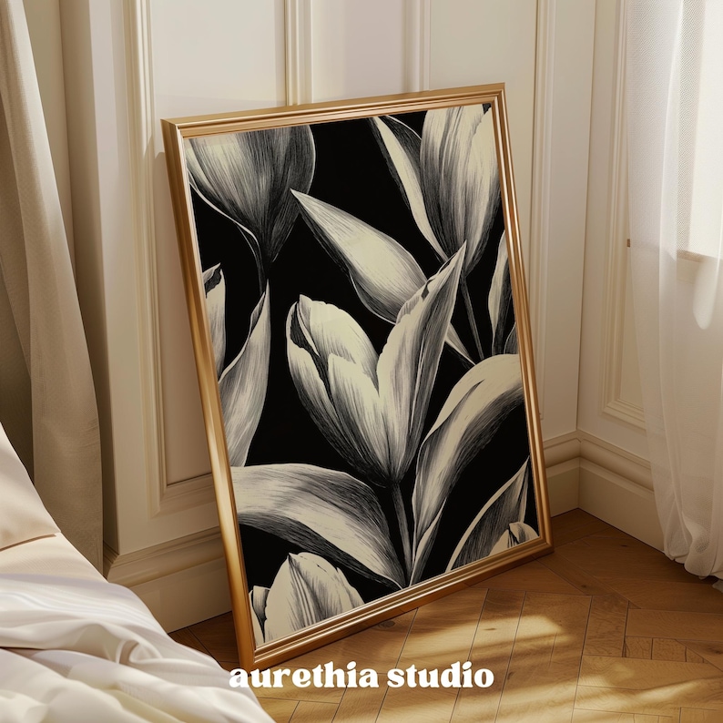 May include: A black and white floral print in a gold frame. The print features large, stylized tulips with a black background.