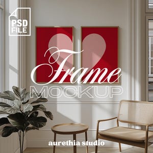 Puede incluir: Dos impresiones artísticas enmarcadas con fondos rojos y formas de corazón rosas. Las palabras "Frame Mockup" se muestran en escritura blanca. Una pequeña mesa de madera y una silla de mimbre están en primer plano. La imagen incluye una planta en maceta y el texto "aurethia studio".