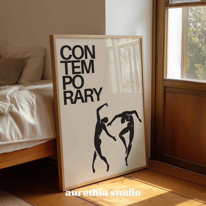 May include: A framed art print with the word "CONTEMPORARY" in large black block letters. Below the text are two black silhouette figures in a dancing pose. The print is in a room with a bed and a window.