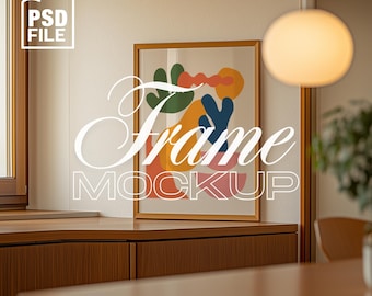 May include: A gold frame mockup with a colorful abstract print inside. The frame is hanging on a white wall above a wooden cabinet. The text "Frame Mockup" is written in white cursive letters over the image. The text "aurethia studio" is written in white letters at the bottom of the image.