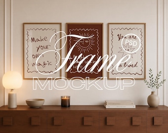 May include: Three rectangular wooden frames containing white and dark brown prints with line art of a sun and stars, featuring the text Make your own magic, You are loved, and other phrases, displayed on a dark wooden cabinet with a lamp and vase.