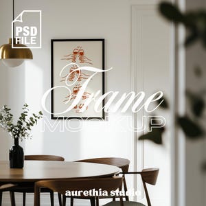 May include: A black framed print featuring a red illustration of hands holding up glasses of wine. The print is hanging on a white wall in a dining room with a wooden table and chairs.