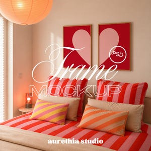May include: Two vertical rectangular frames with light wood borders hanging on a wall, each containing a red and pink heart graphic. The text "Frame MOCKUP" and "PSD" is overlaid in white. The scene includes a bed with striped bedding and pillows.