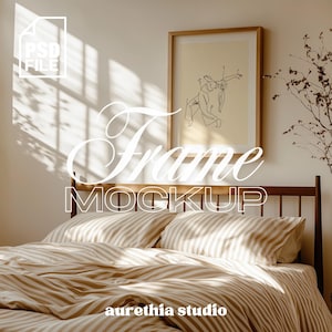 Puede incluir: Interior de dormitorio con una obra de arte enmarcada sobre una cama con ropa de cama a rayas. La obra de arte presenta un sencillo dibujo lineal. Las palabras "Frame Mockup" se muestran en una fuente decorativa. La imagen tiene una paleta de colores cálidos y neutros.