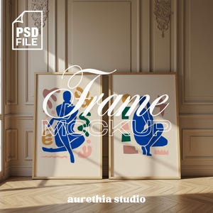 以下が含まれることがあります： クリーム色の背景に、青、緑、ピンクの抽象的な人物が描かれた2つの額入りアートプリント。フレームは明るい木材です。「Frame Mockup」の文字が白い筆記体で上部に書かれています。画像の下部には「aurethia studio」の文字があります。