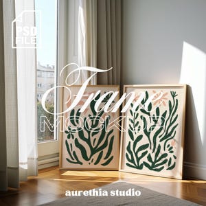 Puede incluir: Dos impresiones artísticas enmarcadas con diseños botánicos. Las impresiones presentan patrones florales y de hojas verdes y melocotón sobre un fondo crema. Los marcos son de madera clara. El texto "Frame Mock" está en la imagen.