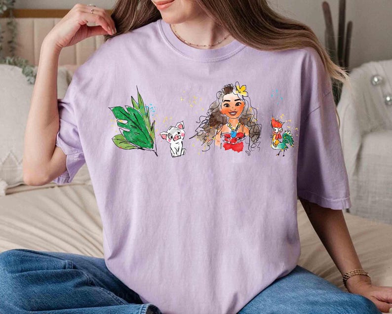May include: A light purple short-sleeve t-shirt featuring a watercolor-style graphic print. The design includes a green tropical leaf, a small white pig, a female character with long brown hair and a yellow flower, and a colorful rooster.