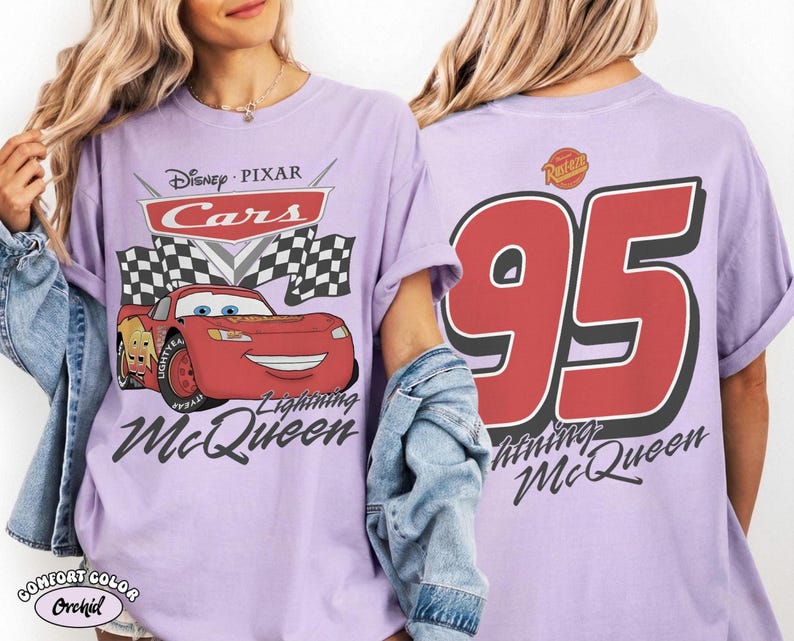 Pu&ograve; includere: Una maglietta lilla con Lightning McQueen di Cars di Disney Pixar. La grafica frontale include il logo Cars, una bandiera a scacchi e Lightning McQueen. Il retro mostra un grande "95" e la scritta "Lightning McQueen".