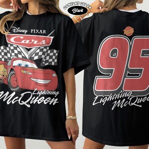 Pu&ograve; includere: T-shirt nero con Lightning McQueen di Cars di Disney Pixar. La grafica frontale include il logo Cars, una bandiera a scacchi e un'auto da corsa rossa sorridente. Il retro mostra il numero 95 e il nome di Lightning McQueen.