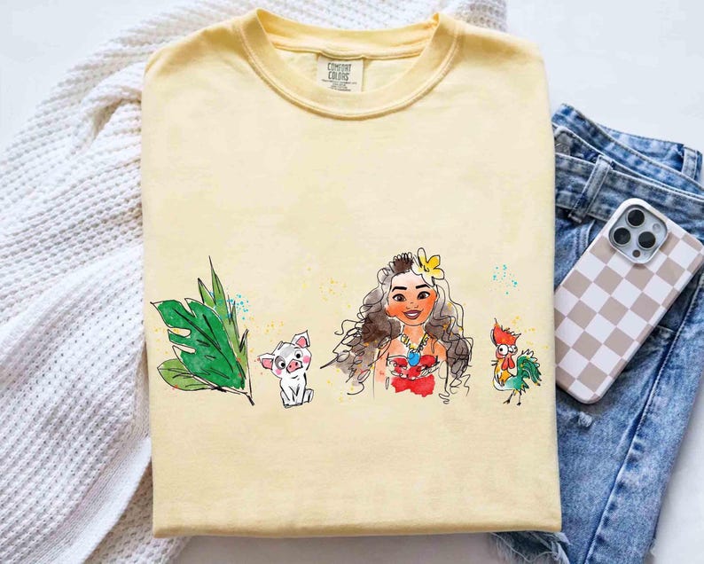 May include: A pale yellow short-sleeve t-shirt featuring a watercolor-style graphic print. The design displays a green tropical leaf, a small white pig, a long-haired character with a yellow flower in their hair, and a colorful rooster.