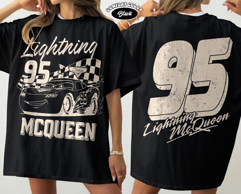 May include: Black Lightning McQueen t-shirt with a large graphic on the front featuring the number 95, a race car, and the name McQueen. The back of the shirt also has the number 95 and the name Lightning McQueen.