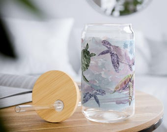 May include: A glass can with a bamboo lid and a straw. The can has a watercolor design of sea turtles swimming in the ocean.