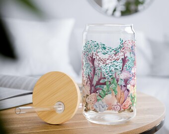 May include: A glass reusable water bottle with a bamboo lid and straw. The bottle features a colorful underwater scene with coral, fish, and seashells.