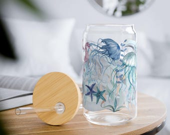 May include: A glass reusable water bottle with a bamboo lid and straw. The bottle has a colorful design of jellyfish, seaweed, and starfish.