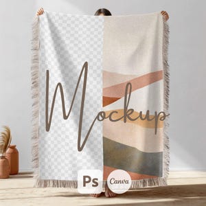 Op de afbeelding: Een geweven deken met een geometrisch patroon in tinten bruin, beige en roze. De deken heeft franjes aan alle kanten en de tekst "Mockup" staat op de deken. De tekst "Ps Canva" is ook zichtbaar op de deken.