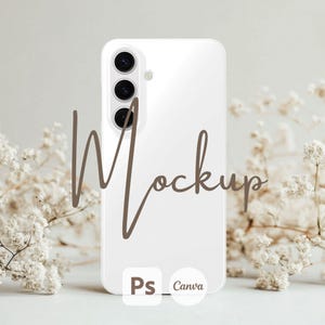 May include: White smartphone mockup with a triple lens camera and the word "Mockup" written in brown cursive. The phone is sitting on a white surface with white flowers in the background. The text "Ps Canva" is visible at the bottom of the image.