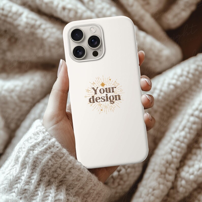 Silicone Phone Case Mockup of an iPhone held by a young woman's hand in front of some cozy beige wool blankets. Works in Photoshop, Photopea and Canva.