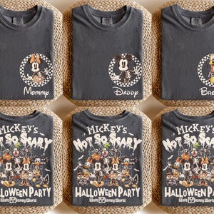 May include: Six charcoal gray t-shirts. Three shirts have a circular graphic with a character and the words "Mommy", "Daddy", and "Brother". The other three shirts have a Halloween-themed graphic with the text "Mickey's Not So Scary Halloween Party Walt Disney World".