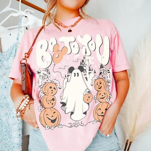 May include: Pale pink t-shirt with a Halloween graphic. The design includes a ghost, pumpkins, and the text "Boo to You". The tee has a relaxed fit and short sleeves, ideal for the spooky season.