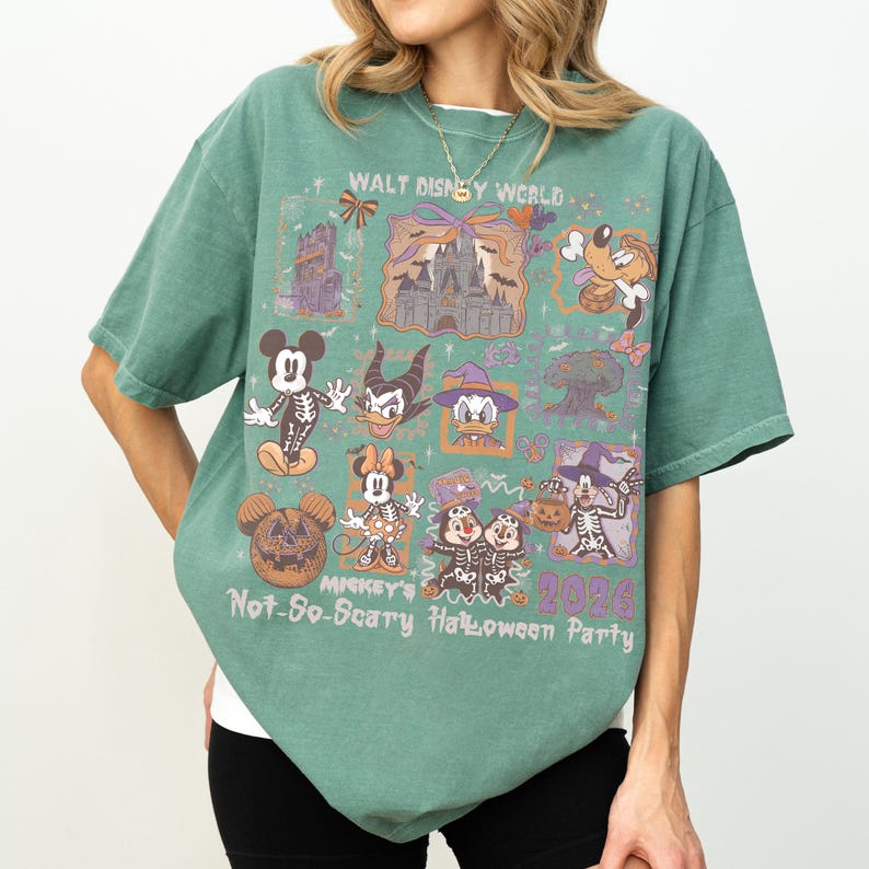 May include: Green t-shirt featuring a graphic design for the Mickey's Not-So-Scary Halloween Party at Walt Disney World. The design includes various Disney characters in Halloween costumes, the text "2026", and a pumpkin Mickey Mouse.