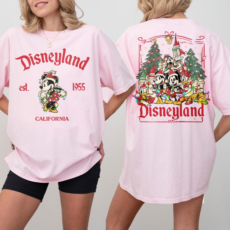 May include: Pink Disneyland t-shirts. The front features Mickey Mouse with text "Disneyland est. 1955 CALIFORNIA". The back has a Disneyland graphic with characters and text "Disneyland 1971".