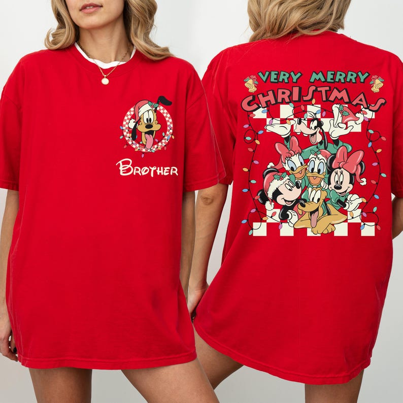 May include: Red t-shirt featuring a festive design. The front displays a cartoon character in a Santa hat with the word "Brother". The back showcases a group of cartoon characters with the text "Very Merry Christmas" and string lights.