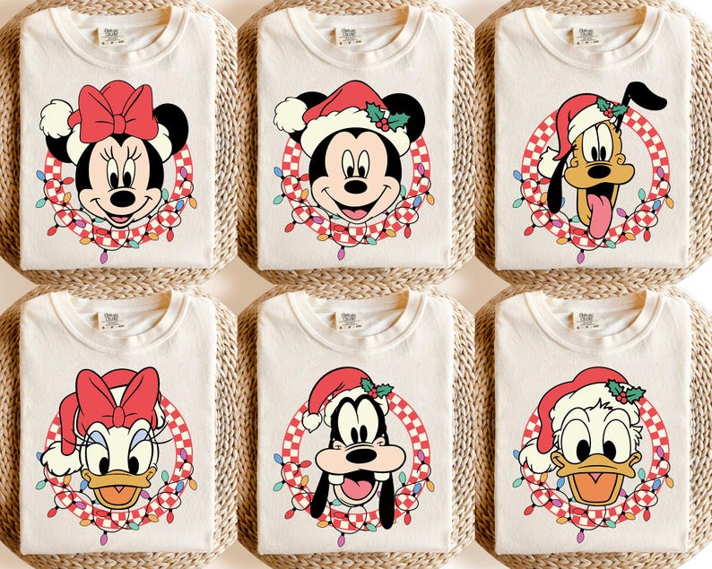 May include: Six cream-colored t-shirts featuring Disney characters in Santa hats and festive wreaths. Minnie Mouse, Mickey Mouse, Pluto, Donald Duck, Goofy, and Daisy Duck are depicted. Each shirt has a unique character design, perfect for holiday celebrations.