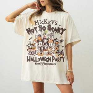 May include: Cream-colored oversized t-shirt featuring a Halloween-themed graphic. The design includes Mickey Mouse and friends in spooky costumes, with the text "Mickey's Not So Scary Halloween Party" and "Walt Disney World".