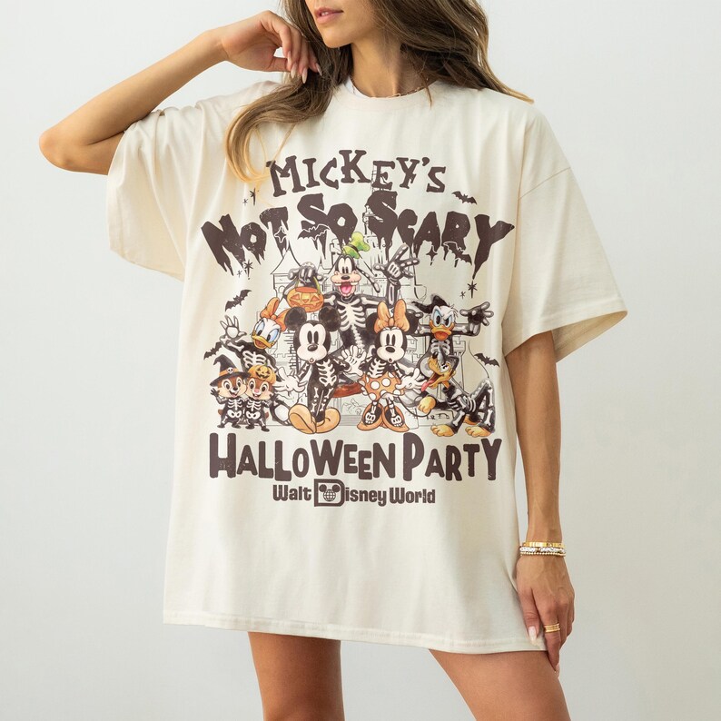 May include: Cream-colored oversized t-shirt featuring a Halloween-themed graphic. The design includes Mickey Mouse and friends in spooky costumes, with the text "Mickey's Not So Scary Halloween Party" and "Walt Disney World".