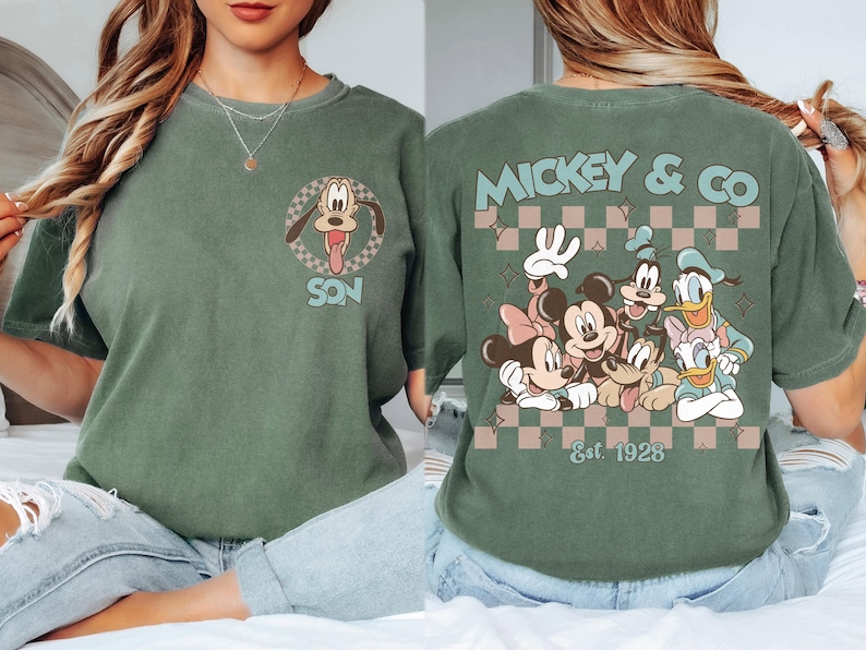 K&ouml;nnte beinhalten: Gr&uuml;nes T-Shirt mit Pluto und dem Wort "SON" in einem Kreis auf der Vorderseite. Auf der R&uuml;ckseite sind Micky Maus, Minnie Maus, Goofy, Donald Duck und Daisy Duck mit "Mickey & Co" und "Est. 1928" abgebildet.