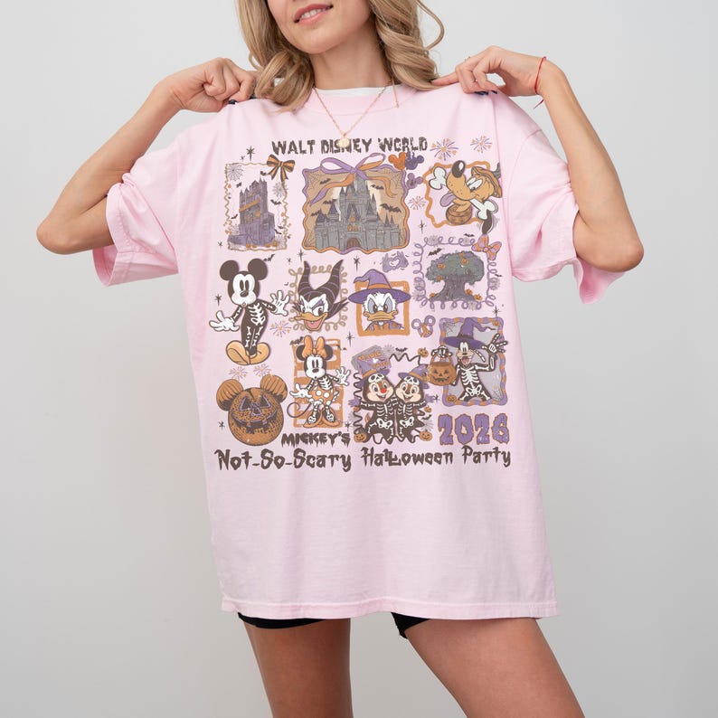 May include: A light pink t-shirt featuring a colorful graphic design with various Disney characters and the text "WALT DISNEY WORLD" and "Mickey's Not-So-Scary Halloween Party 2026". The shirt has short sleeves.