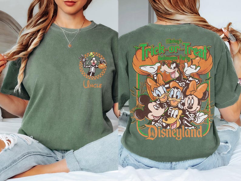May include: A sage green t-shirt featuring a small graphic on the front chest of Goofy in a skeleton costume with the word Uncle. The back displays a large graphic of Mickey, Minnie, Donald, Daisy, and Goofy in skeleton costumes with the text Mickey's Trick-or-Treat Halloween Party Disneyland.