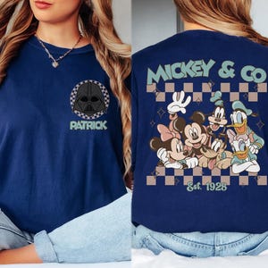 K&ouml;nnte beinhalten: Marineblaues T-Shirt mit Darth Vader-Grafik und dem Namen "Patrick" auf der Vorderseite. Auf der R&uuml;ckseite steht "Mickey & Co" mit Disney-Figuren und "Est. 1928". Das T-Shirt hat einen Rundhalsausschnitt und kurze &Auml;rmel.