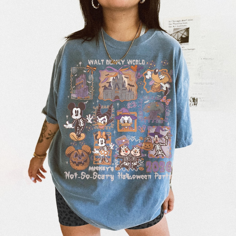 May include: Blue t-shirt featuring a colorful graphic design with the text "Walt Disney World" and "Mickey's Not-So-Scary Halloween Party 2026". The design includes various Disney characters in Halloween costumes.