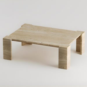 May include: A rectangular coffee table made of light beige stone. The table has a simple, modern design with a flat top and four thick, rectangular legs. The stone has a natural, textured appearance.
