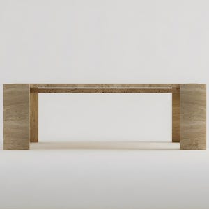 May include: A rectangular, light-colored stone table with a minimalist design. The table has a long, flat top supported by two thick, rectangular legs at each end. The table is approximately 72 inches long.