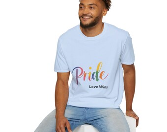 Op de afbeelding: Een lichtblauw T-shirt met een regenboogkleurige "Pride"-afbeelding en de tekst "Love Wins" in zwart.
