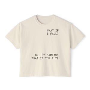 May include: A cream coloured t-shirt with the text "WHAT IF I FALL?" and "OH, MY DARLING WHAT IF YOU FLY?" printed on the front.