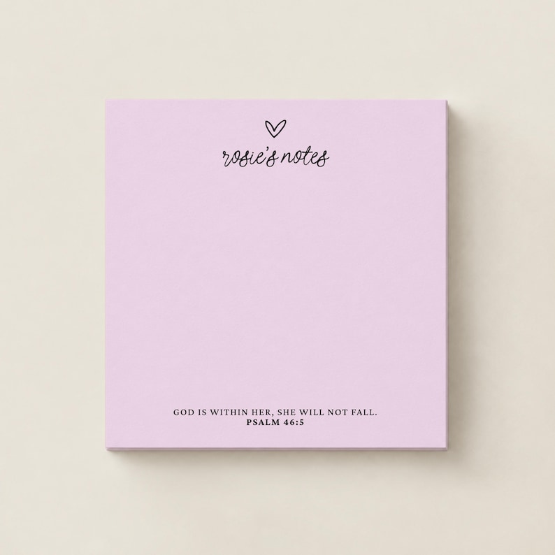 May include: A square light purple notepad featuring a small black heart icon above the text "rosie's notes" in a cursive font. At the bottom, the text "GOD IS WITHIN HER, SHE WILL NOT FALL. PSALM 46:5" is printed in a clean, black sans-serif font.