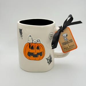 Snoopy Halloween mug by Rae Dunn | Peanuts SNOOPY mug with Snoopy graphic resting on a jack o lantern | Great for Snoopy themed baskets