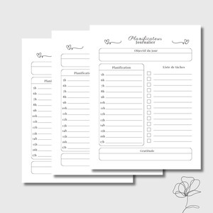 May include: Three white daily planner sheets with a minimalist design. Each sheet features a section for scheduling, a to-do list, and the words "Planificateur Journalier" and "Objectif du jour" in French. The sheets are adorned with small heart illustrations.
