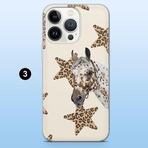 Puede incluir: Funda transparente para tel&eacute;fono con un dise&ntilde;o de cabeza de caballo con manchas marrones y blancas, una brida marr&oacute;n y estrellas con estampado de leopardo sobre un fondo crema. La funda tiene un recorte para la c&aacute;mara y el n&uacute;mero 3.
