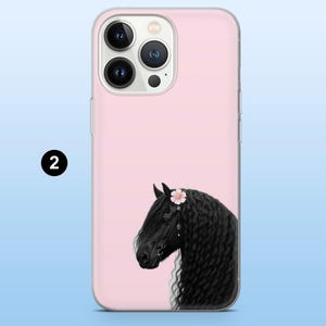 Puede incluir: Funda de tel&eacute;fono rosa con la cabeza de un caballo negro con una corona de flores. El caballo tiene una larga melena ondeante sobre un fondo rosa claro. La funda tiene un borde transparente y un recorte para la c&aacute;mara.