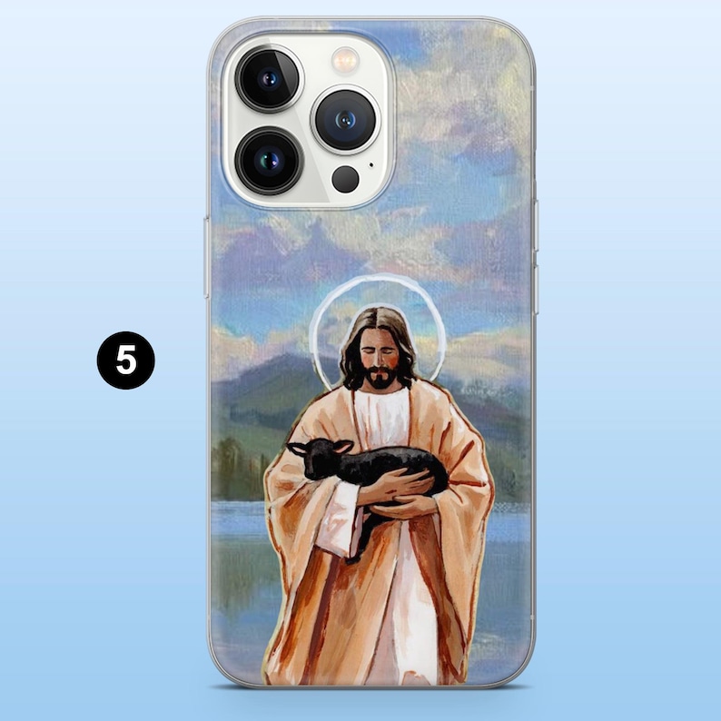May include: Clear phone case featuring a painting of Jesus holding a black lamb. The artwork has a halo around Jesus's head and is set against a backdrop of a lake and mountains. The case has a number 5 in a black circle.