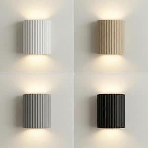May include: Four modern wall sconces in a grid arrangement. Each cylindrical sconce has vertical ribbed detailing. Colors include white, beige, gray, and black. The sconces emit a warm, downward-facing light.